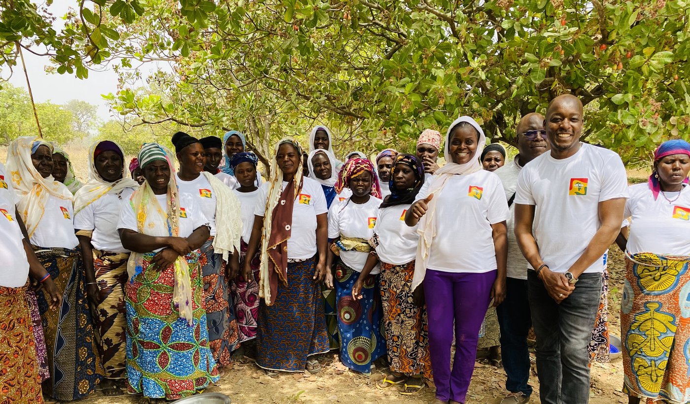 Frauen der Kooperative gemeinsam mit Simon Debade unter Cashewbäumen in Benin